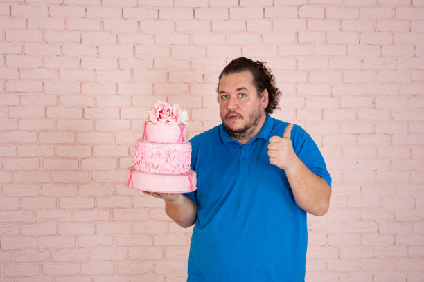 滑稽的胖子梦见甜甜圈和蛋糕。图片下载