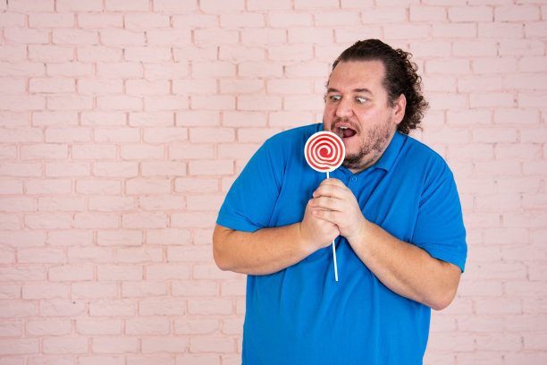 滑稽的胖子梦见甜甜圈和蛋糕。图片下载