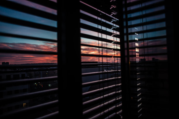 一名女子在阳台上欣赏日落时的城市景色图片下载