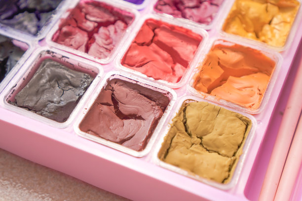 特写照片干彩色水粉在粉红色的绘画调色板盒散景背景。碎裂水彩图片下载