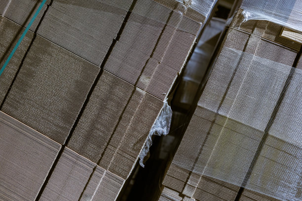 折叠纸板箱。有孔的瓦楞纸板堆在托盘上。工业生产中成品的包装。图片下载