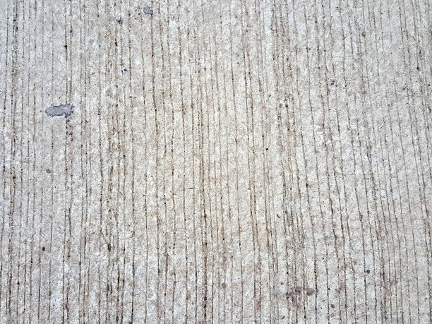 一个人拿着滑板走在人行道上的照片，混凝土表面粗糙，中间有一个小洞。图片下载