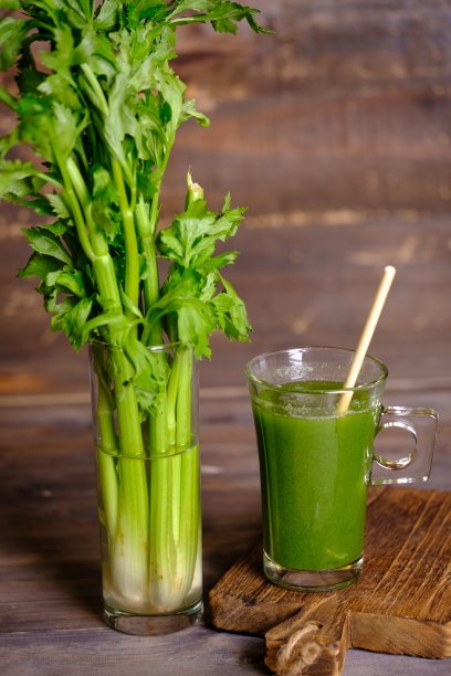 汁液Seledri。透明玻璃杯和瓶子里的芹菜汁。芹菜是一种叶子蔬菜和药用植物，通常用作烹饪香料。这种果汁对健康有益，是减肥饮料和健康饮料。图片下载