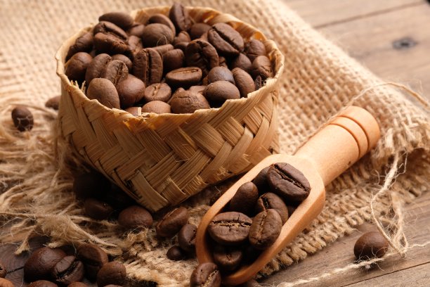 咖啡豆是咖啡树的种子，也是咖啡的原料。用竹编容器装咖啡豆。《咖啡。木匙。图片下载