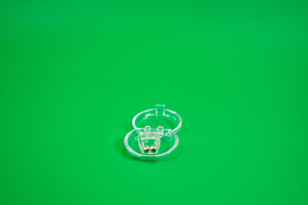 图片显示一个小装置，插入到鼻子扩大呼吸系统，减少打鼾，绿色背景。图片下载