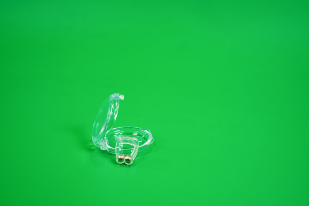 图片显示一个小装置，插入到鼻子扩大呼吸系统，减少打鼾，绿色背景。图片下载