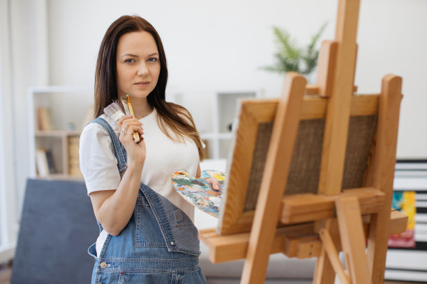 漂亮的艺术家用画笔选择绘画的颜色图片下载