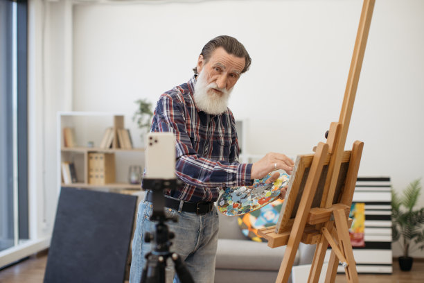 资深画家用白色智能手机录制视频图片下载