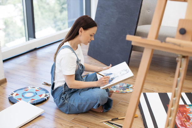 专注的女士在时尚的家庭工作室里画新画图片下载