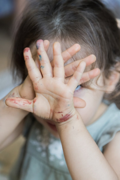 可爱的小女孩在完成水彩画活动后展示她的双手。理念学习，技能培养，童年快乐。关注前景。图片下载