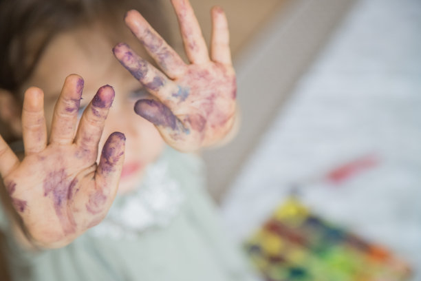 可爱的小女孩在完成水彩画活动后展示她的双手。理念学习，技能培养，童年快乐。关注前景。图片下载