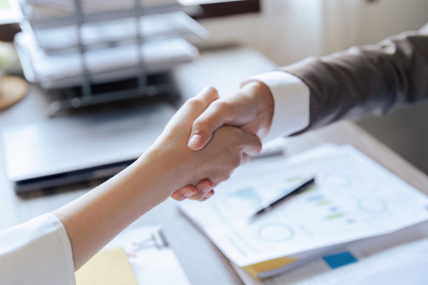 (特写)商务人士和合作伙伴在办公室策划营销策略后握手图片下载