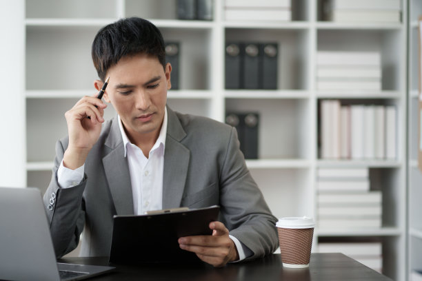 成功的亚洲商人专注于他的项目，在办公室工作。图片下载