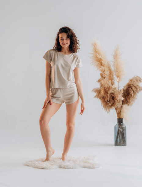 穿着睡衣的卷发年轻女子的肖像。在家中休息，孤立在白色背景的工作室肖像。放松好心情概念图片下载