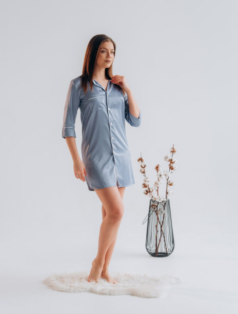 女人穿着白色背景的蓝色丝绸睡袍图片下载