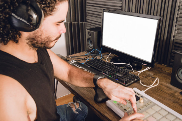 侧面视图的人在他的家庭工作室制作音乐与MIDI控制器图片下载