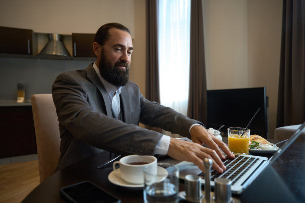 中年商人在早餐时上网聊天图片下载