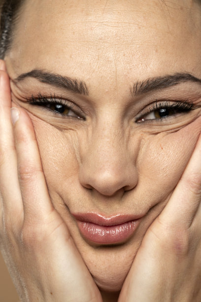 一位年轻女子用手揉皱脸上的皮肤图片下载