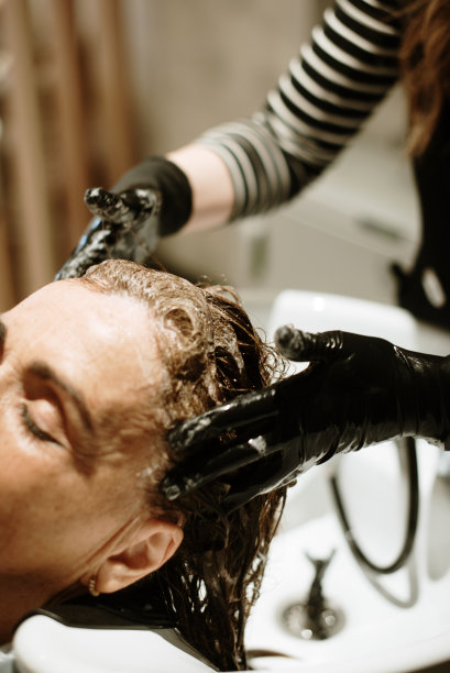 美发师给一个女人洗头的特写图片下载