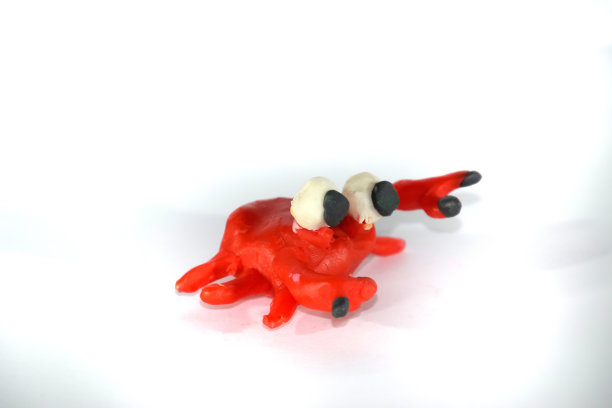 橡皮泥做的红色青蛙。白色背景上的橡皮泥玩具。图片下载