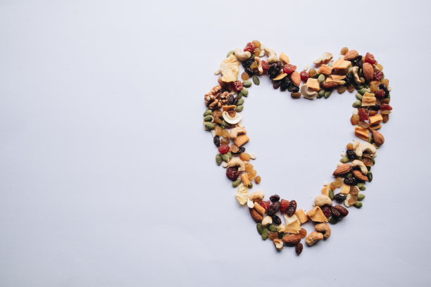 不同类型的有益健康的谷物和干果排列成心形，放置在白色背景上，空白的文字或图像。健康食品和减肥。健康零食创意图片下载