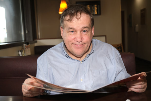 自闭症男性在餐厅里看菜单图片下载