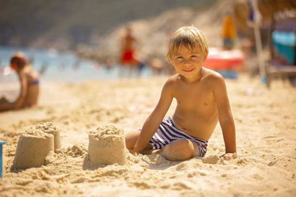 快乐的孩子在沙滩上，堆沙堡，享受夏天，玩耍。希腊图片下载