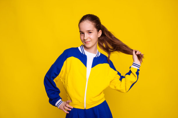 网球运动员穿着运动服站在黄色背景上。运动服装的促销和销售图片下载