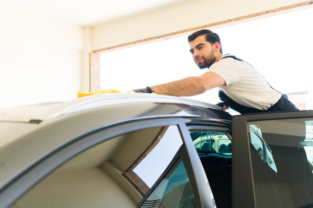 一个年轻人在汽车修理厂洗车图片下载