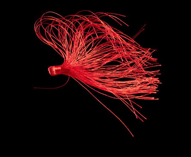 装饰用红丝流苏。印度文化中挂流苏是为了让风动起来，看起来很优雅。流苏有许多颜色在空中纺纱。黑色背景孤立的冻结运动图片下载