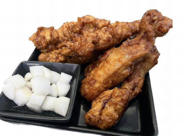 一张照片上有一盘食物，里面有一些肉，黑色盘子里有一些鸡肉和一些方糖。图片下载