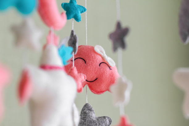 婴儿床移动与星星，云和月亮。孩子们在婴儿床上方手工制作玩具。图片下载