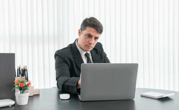 商人坐在现代办公室的工作桌旁分析公司业绩、财务和投资图片下载