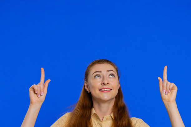 成年妇女竖起大拇指，指着头顶空白的地方，广告标志的地方图片下载