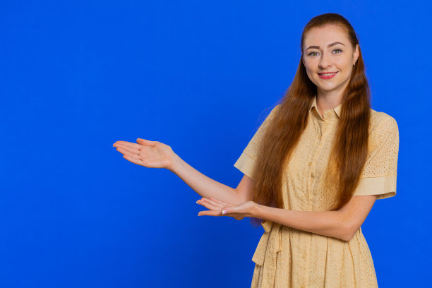 年轻女子竖起大拇指，指着左边空白的地方，你的广告标志的地方图片下载