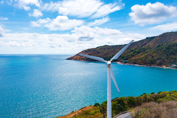 风力涡轮机在山和蓝色的海洋背景与文本的复制空间。图片下载