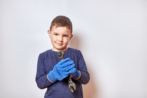 帅气的小男孩拿着扳手。图片下载