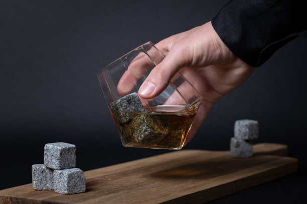 钻石威士忌酒杯，倒入冰块和威士忌，放在木制托盘上。被酒保接走了。图片下载