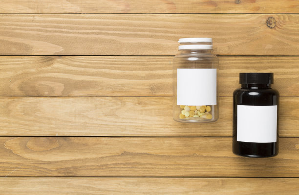 木制背景上有维他命的塑料瓶，俯视图图片下载