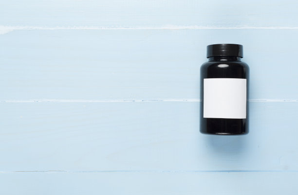 木制背景上的维他命塑料瓶，俯视图图片下载