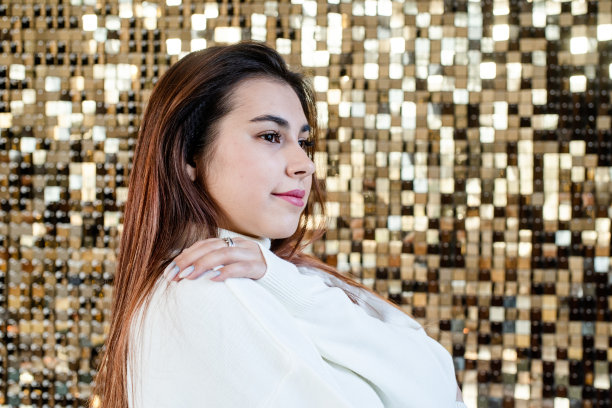 在闪亮的金色背景上穿着温水的女人图片下载