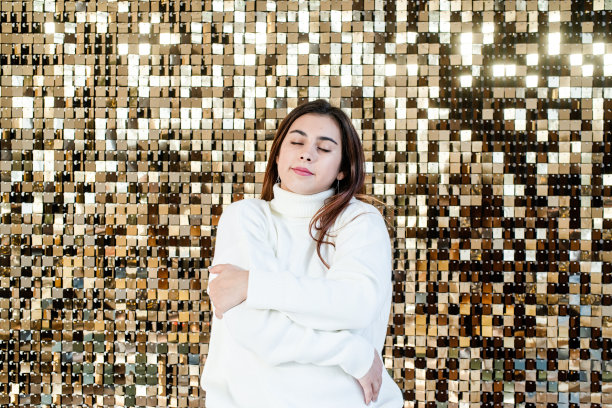 在闪亮的金色背景上穿着温水的女人图片下载