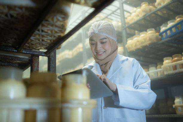 年轻的亚洲穆斯林女科学家在蘑菇工厂做研究，在无菌温控的房间里检查蘑菇发酵剂。图片下载