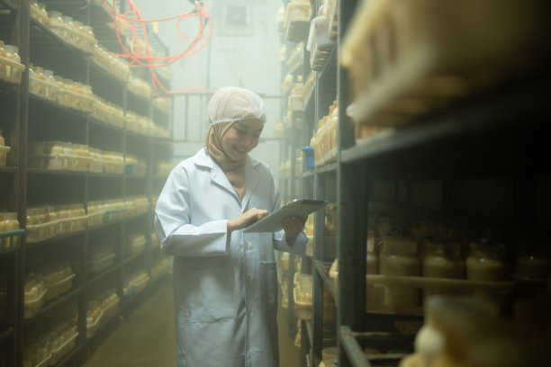 年轻的亚洲穆斯林女科学家在蘑菇工厂做研究，在无菌温控的房间里检查蘑菇发酵剂。图片下载