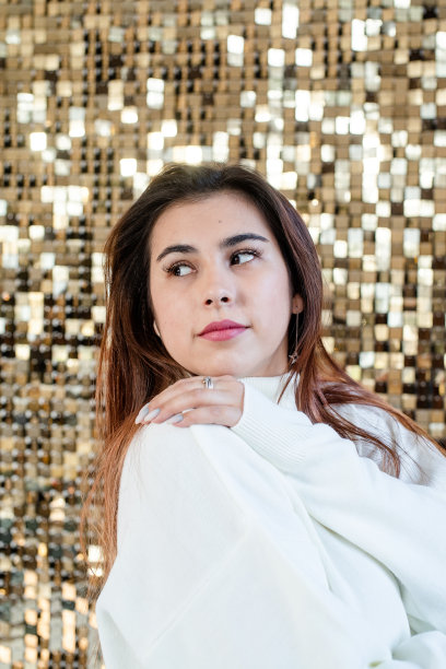 在闪亮的金色背景上穿着温水的女人图片下载