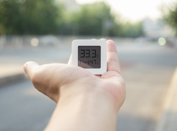 炎热的夏季户外，手持温度计特写图片下载