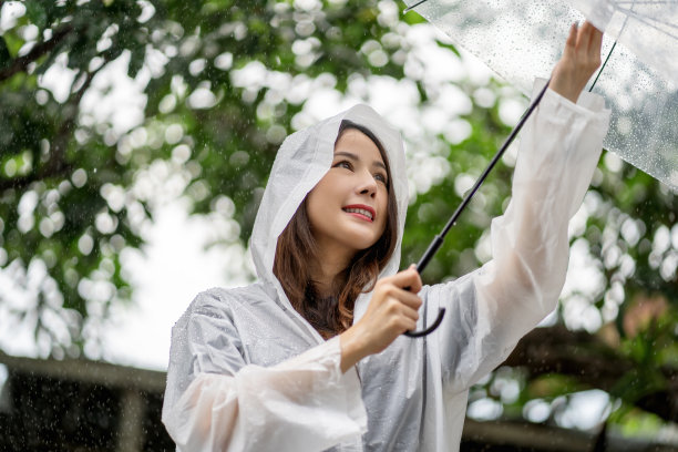 微笑着的亚洲美女撑着伞，快乐着雨图片下载