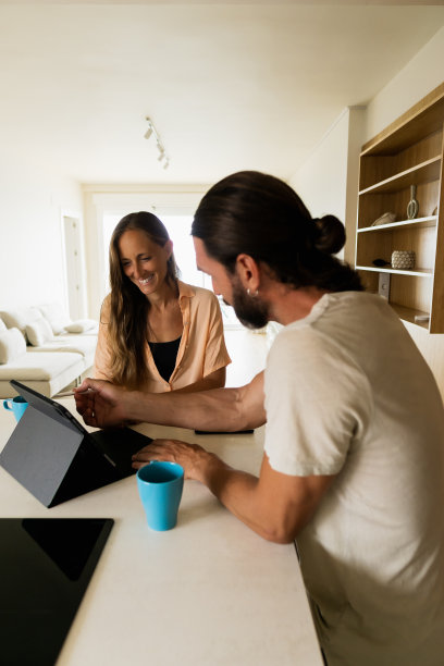 一男一女在厨房里一边用平板电脑一边聊着生意图片下载