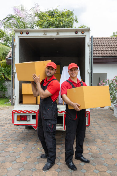 两名搬运工从一辆皮卡车上卸下箱子和家具。图片下载