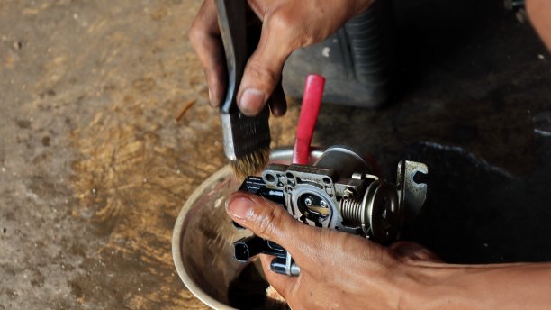 当地的机械师用汽油清洗摩托车的化油器图片下载